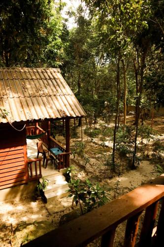 a pavilion with a bench and a hut in a forest at Sambath Sakseth Bungalow in Koh Rong Island