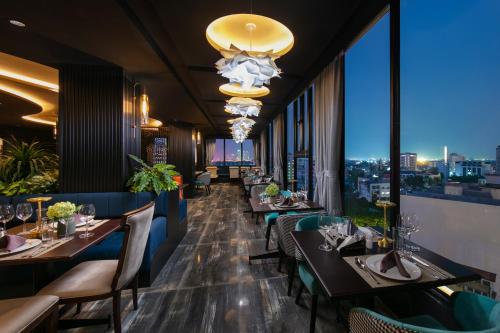 a restaurant with tables and chairs and a view of the city at MAY DE VILLE Corner Hotel in Hanoi