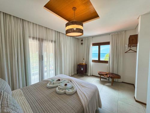 a bedroom with a bed and a large window at Junduh Brasil Pousada e Restaurante in Icaraí