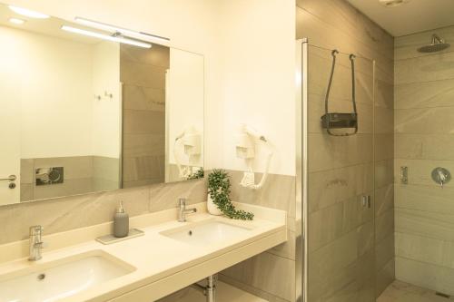 ein Badezimmer mit zwei Waschbecken und einer Dusche in der Unterkunft Villa Eden Sky in Prazeres in Prazeres