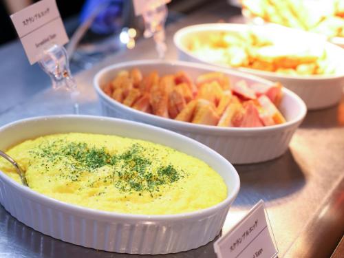 姫路市にある天然温泉 白鷺の湯 ドーミーイン姫路のディップのボウル3つとフルーツが置かれたテーブル