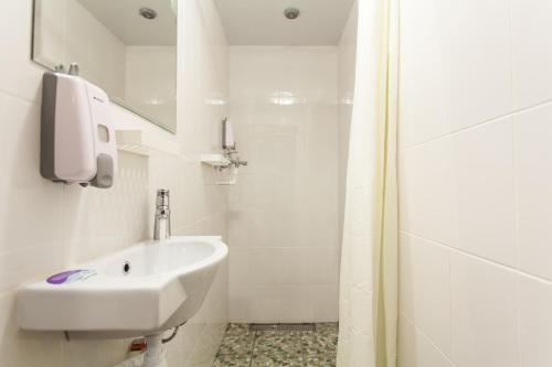 a white bathroom with a sink and a shower at WinterFell On Arbat Hotel in Moscow