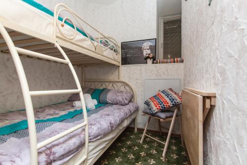 モスクワにあるWinterFell On Arbat Hotelの二段ベッド2台と椅子が備わる二段ベッドルーム1室です。