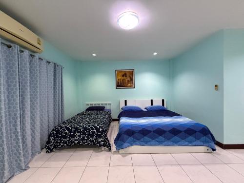 a bedroom with two beds with blue walls at Best Rent a Room in Nai Yang Beach