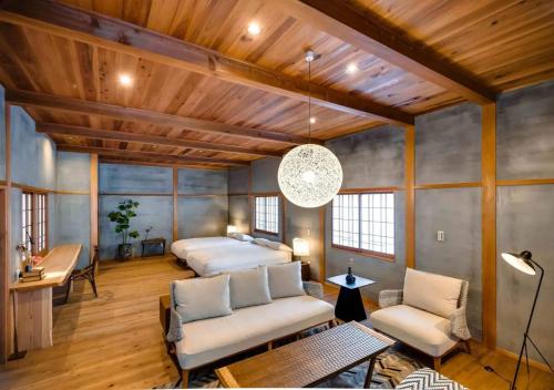 a living room with two beds and a table at NIPPONIA Sawara Merchant Town Hotel in Katori