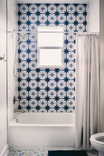 a bathroom with a white tub and a window at The Board House Longboard in Galveston