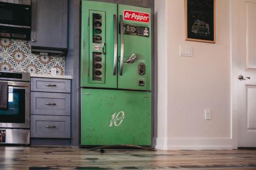 a green refrigerator in a kitchen next to a wall at The Board House Longboard in Galveston