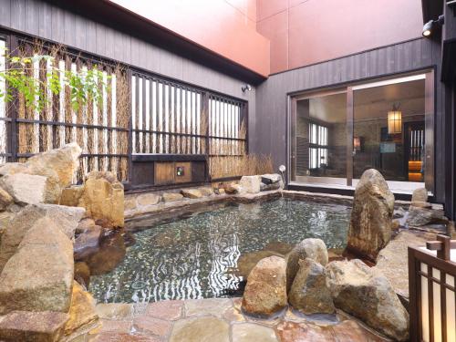 a pool of water with rocks in a house at Dormy Inn Himeji Natural Hot Spring in Himeji