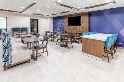 a waiting room with tables and chairs and a tv at Holiday Inn Express Hotel & Suites Cheyenne by IHG in Cheyenne