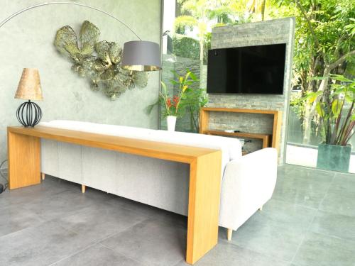 a living room with a couch and a tv at Phuket 4-Bedrooms Seaview 884m2 Private XL Luxury Infinity Pool Villa in Ban Pa Khlok
