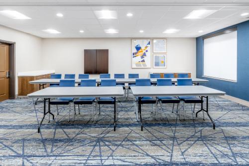 a conference room with tables and blue chairs at Holiday Inn Express Hotel & Suites Cheyenne by IHG in Cheyenne