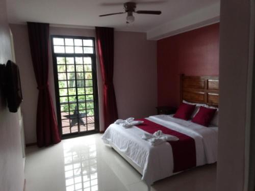 a bedroom with two beds with red walls and a window at Answer hotel in Puerto Galera
