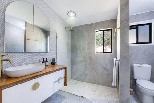 a bathroom with a sink and a toilet and a shower at Rosewood House in Lower Beechmont