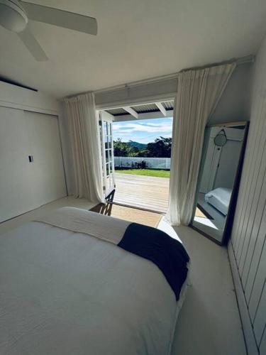 a bedroom with a bed and a large window at Rosewood House in Lower Beechmont
