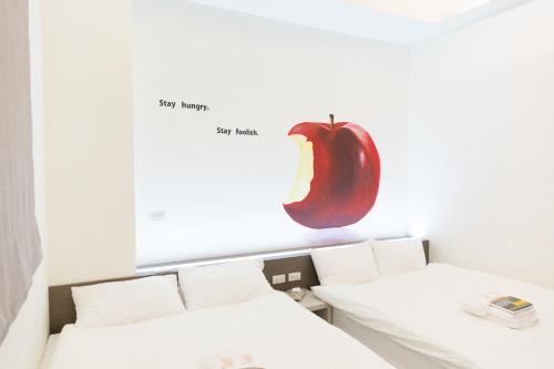 a picture of an apple on the wall above a bed at Tiin Tinn - Rivershore B&B in Taitung City