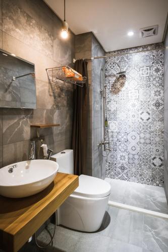 a bathroom with a sink and a toilet and a shower at Tiin Tinn - Rivershore B&B in Taitung City