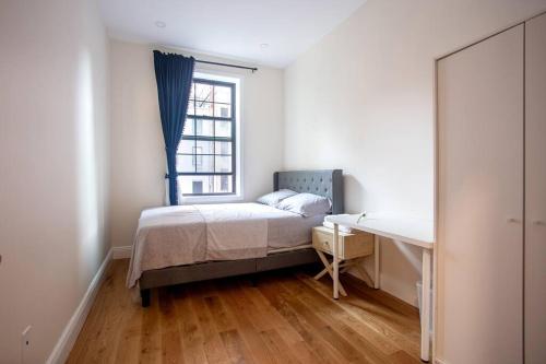 a bedroom with a bed and a window and a desk at Little manhattan near Time Square in New York
