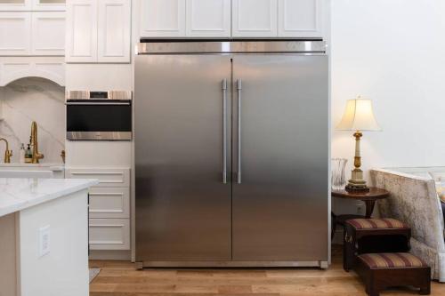 a stainless steel refrigerator in a kitchen with white cabinets at Little manhattan near Time Square in New York