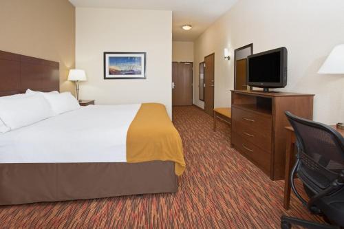 a hotel room with a bed and a flat screen tv at Holiday Inn Express & Suites Truth Or Consequences by IHG in Truth or Consequences