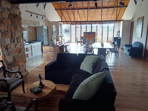 a living room with a couch and a kitchen and a table at Parcela Monte Alto Galería in Los Santos