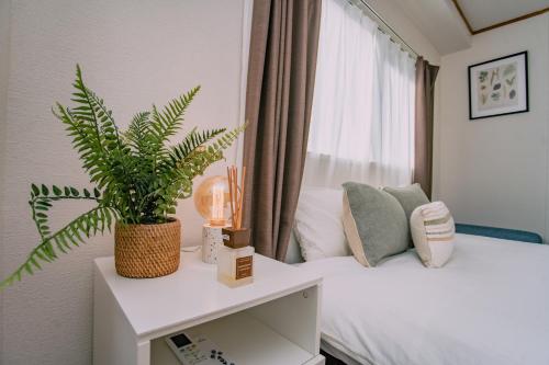 a bedroom with a potted plant sitting on a bed at Natsumi 2 ホテル in Tokyo