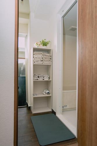 a walk in closet with a mirror and a shelf at Natsumi 2 ホテル in Tokyo