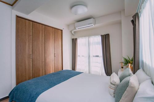 a bedroom with a bed and a large window at Natsumi 2 ホテル in Tokyo