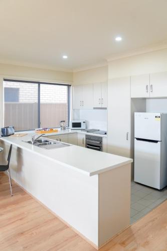 a kitchen with white appliances and a white counter top at Villas on the Bay Kingscote in Kingscote