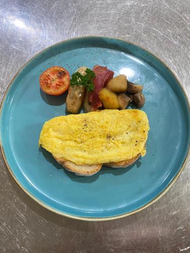 un piatto blu di cibo con omelette e patate di Samujha Ubud Resort ad Ubud