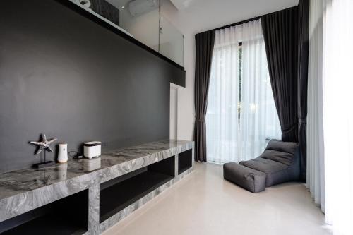 ein Wohnzimmer mit einem Tisch und einem Stuhl in der Unterkunft Futuristic Pool Villa with Stunning Mountain View in Chiang Mai