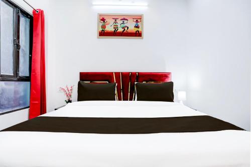 a bedroom with a large white bed with a red headboard at Hotel O Virat Inn in Lucknow