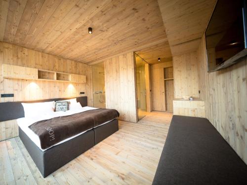 a bedroom with a large bed and wooden walls at Das Wiesegg in Fügenberg