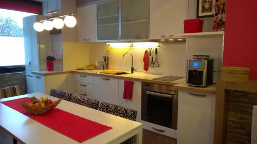 a kitchen with a table with a bowl of fruit on it at Parkview Apartments in Sofia