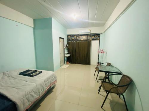 Un dormitorio con una cama, una mesa y una silla. en Walking Street Pattaya Beach Ordinary Rooms Guest House วอล์คกิ้งสตรีทพัทยาชายหาดพัทยาห้องธรรมดาเกสท์เฮ้าส์, en Pattaya central
