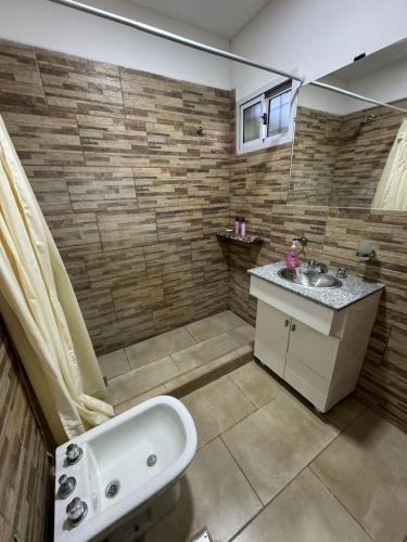a bathroom with a sink and a bath tub at La posada de Majo 2 in Pergamino