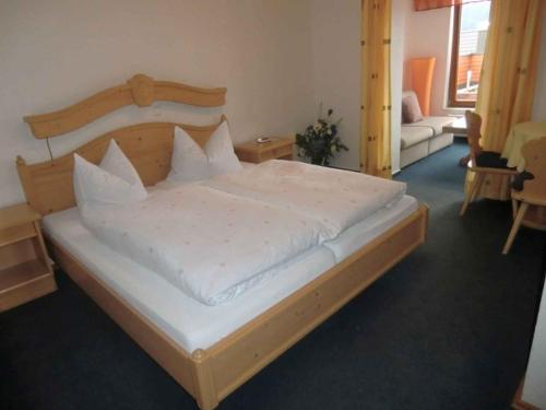 a bedroom with a large bed with a wooden headboard at Landhaus Panoramablick in Schonach