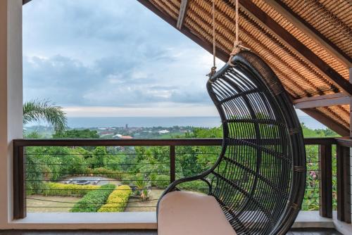ein Schaukelstuhl auf einem Balkon mit Aussicht in der Unterkunft Villa Lakshmi in Temukus