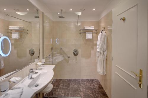 a bathroom with a sink and a shower at Ensana Nové Lázně in Mariánské Lázně