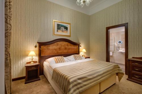 a bedroom with a large bed with two night stands and two lamps at Ensana Nové Lázně in Mariánské Lázně