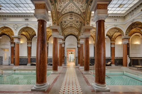 a pool in a building with columns and ceilings at Ensana Nové Lázně in Mariánské Lázně