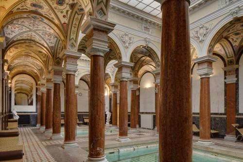 a large room with columns and ceilings in a building at Ensana Nové Lázně in Mariánské Lázně