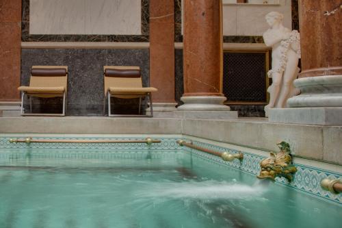 a pool of water in a building with chairs at Ensana Nové Lázně in Mariánské Lázně