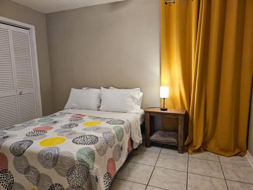 a bedroom with a bed and a table with a lamp at 3BR Family Home Near NAS Pensacola in Pensacola