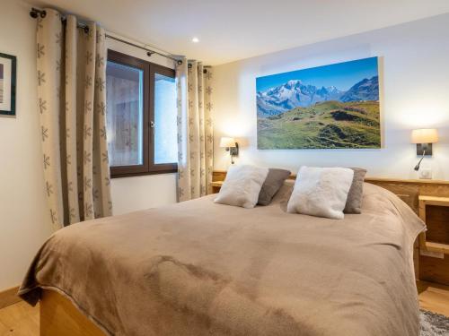 une chambre avec un grand lit avec deux oreillers dans l'établissement Chalet skis aux pieds avec cheminée et parking - FR-1-686-43, à Bourg-Saint-Maurice