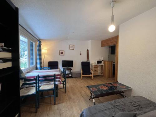 une chambre avec un lit, une table et des chaises dans l'établissement Charmant T2 proche centre, 4-5 pers, cadeau bienvenue - FR-1-812-67, à Cauterets