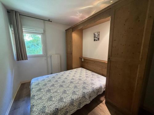 une petite chambre avec un lit et une fenêtre dans l'établissement Appartement avec piscine chauffée, parking et vue montagne à Cauterets - FR-1-812-77, à Cauterets