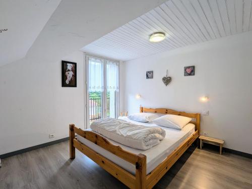 - une chambre avec un grand lit et un cadre de lit en bois dans l'établissement Gîte montagnard La Bresse 4 pers, terrasse, parking, WIFI - FR-1-589-693, à La Bresse