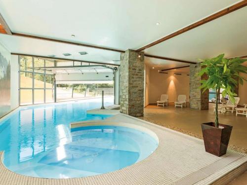 - une grande piscine au milieu d'une maison dans l'établissement Appartement avec piscine chauffée, parking et vue montagne à Cauterets - FR-1-812-77, à Cauterets