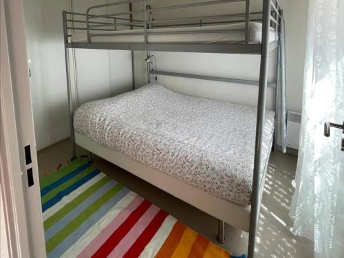 Ce lit superposé se trouve dans un dortoir doté d'un tapis coloré. dans l'établissement Appartement familial à Cauterets, proche centre - FR-1-812-32, à Cauterets