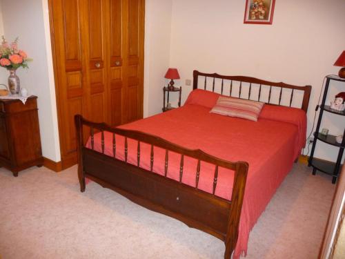 une chambre avec un grand lit avec une couverture rouge dans l'établissement Maison à Proissans: Confort, Cour Close, Près de Sarlat - FR-1-616-390, à Proissans